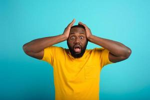 Amazed and shocked expression of a boy over cyan background photo
