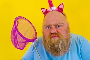 Fat thoughtful man with headband play with sea net photo