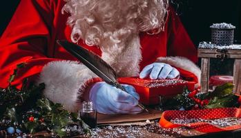 Papa Noel claus escribe un letra bueno deseos para Navidad regalos foto