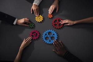 Business team connect pieces of gears. Teamwork, partnership and integration concept photo