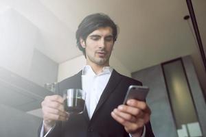 Businessman works with his smartphone at home photo