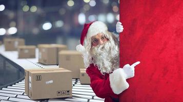 Papa Noel claus indica un espacio para el navidad presente, con Listo paquetes en antecedentes foto