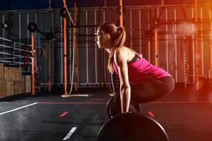 atlético niña trabajos fuera a el gimnasio con un barra con pesas foto