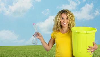 Woman is ready to puts a plastic bottle in the garbage can. photo