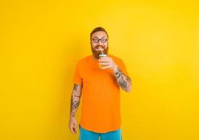 nerd contento hombre con lentes bebidas un Fruta jugo foto