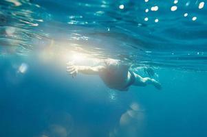 Sporty man swims fast in the sea photo