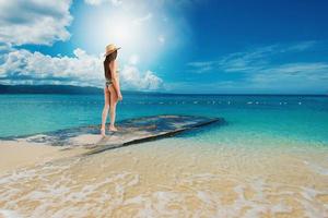 mujer relajante debajo el Dom a el cristalino mar foto