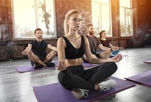 Yoga meditation of young people in lotus pose in fitness center photo