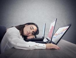 Female worker falls asleep while simultaneously working on three laptops photo