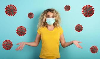 Blonde girl has doubt about covid19 corona virus. Cyan background photo