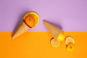 Ice cream with natural orange and lemon fruits. Concept of genuine and biologic fruit. Purple and yellow background photo