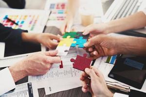 Team of businessmen work together to build a puzzle. Concept of unity and partnership photo
