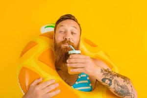 man with life buoy of child drinks a fruit juice photo