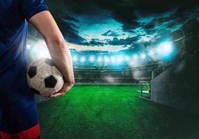 Soccer player ready to play with ball in his hands at the exit of the locker room tunnel photo