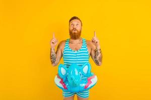 man with inflatable donut with elephant is ready to swim photo