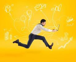 Fast business concept with businessman running with a laptop. Yellow background photo