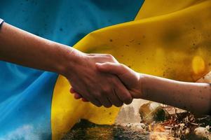 Sunny Ukraine country flag with helping hand as support photo