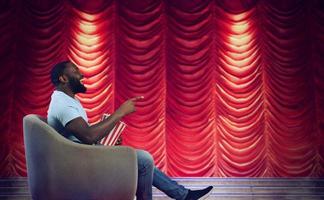 Man sitting on a armchair watches a show in a theatre photo