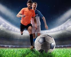 Soccer players play with soccerbal at the stadium photo