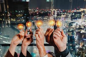 Teamwork and brainstorming concept with businessmen that share an idea with a lamp photo