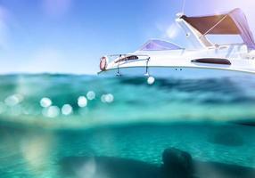 Boat floats in a crystalline and transparent sea photo