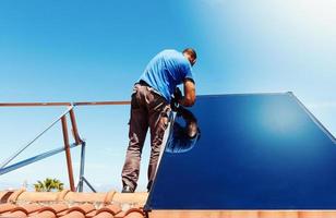 Workers assemble energy system with solar panel hot water photo