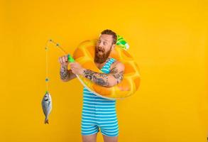 Man with beard and inflatable donut catches fish photo