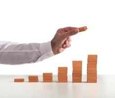 Businessman puts a brick on a bricks pile. Concept of growing statistics and success photo