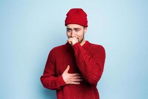 Boy caught a cold and has cough. Studio on Cyan background photo