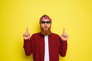 Happy man with beard and bandana in head cries indicates something photo