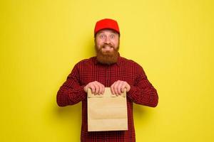 Delivery man with hat and beard has an happy expression photo