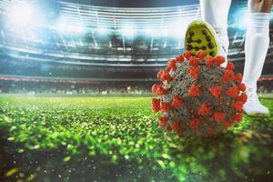 Soccer player with virus ball under the football shoe at the stadium photo