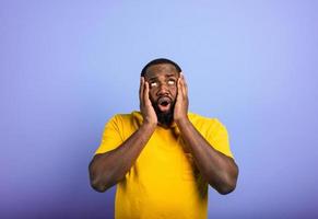 Amazed and shocked expression of a man over purple background photo