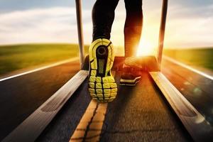 Man run with treadmill made of asphalt during sunrise. Concept of running outdoor photo