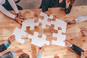 Teamwork of partners connect puzzle pieces as integration and startup photo