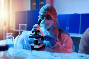 Doctor in the laboratory analyzes samples under a microscope. Pharmaceutical treatment concept. photo