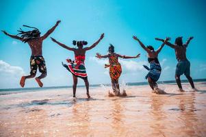 contento personas saltando a el soleado mar foto