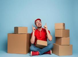 Courier is happy and indicates something above. Studio on cyan background photo