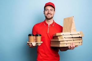 Courier is happy to deliver hot coffee and pizzas. Cyan background photo
