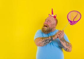 Fat happy man with headband play with sea net photo