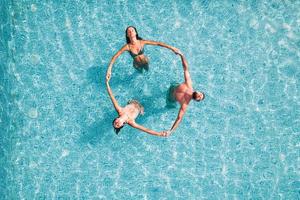 grupo de amigo jugar juntos en un nadando piscina foto