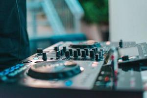 Dj plays disco music with his consolle in a pub photo