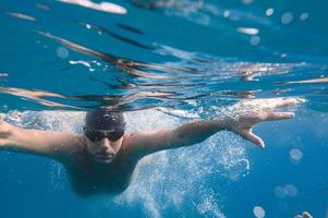 Sporty man swims fast in the sea photo