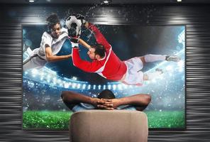 Viewer in front of a tv on the armchair at home feels inside the action photo