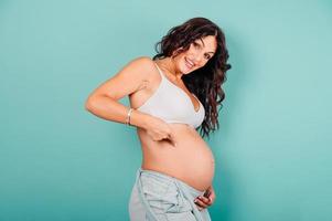 Pregnant happy woman expecting a child caresses her belly photo