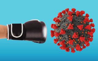 Punch with boxing glove hits the virus on cyan background photo