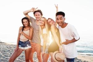 Group of friends having fun on the beach. Concept of summertime photo