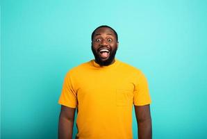 Joyful and happy guy over cyan background photo