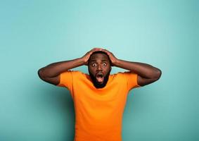 Amazed and shocked expression of a boy over cyan background photo