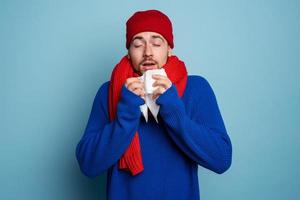 Boy caught a cold and has cold chills. Studio on Cyan background photo